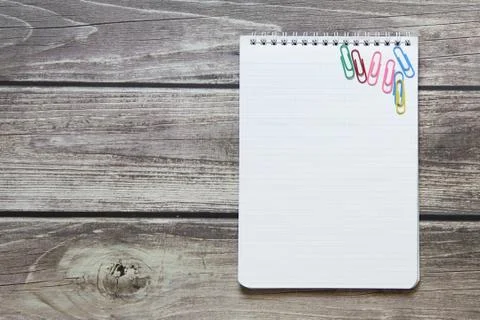 Notepad with a blank white sheet in a checker paper with paper clips lies on  Stock Photos