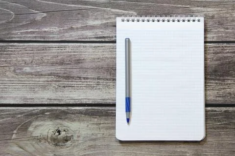 Notepad with a blank white sheet in a checker paper with ball pen lies on the Foto stock