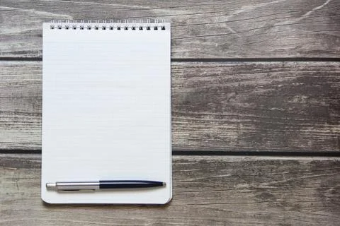 Notepad with a blank white sheet in a checker paper with ball pen lies on the Foto stock