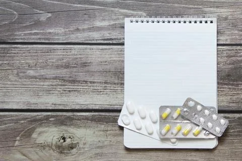 Notepad with a blank white sheet in a checker paper with pills in a blister l Foto stock