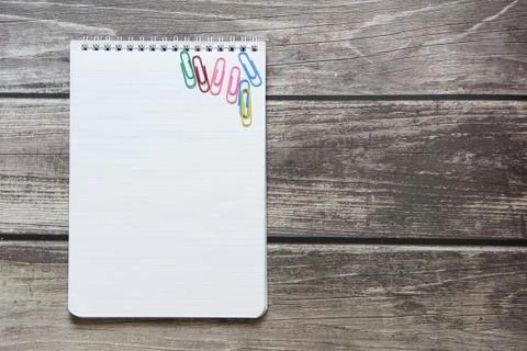 Notepad with a blank white sheet in a checker paper with paper clips lies on  Stock Photos