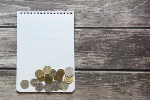 Notepad with a blank white sheet in a checker paper with russian coins lies o Stock Photos