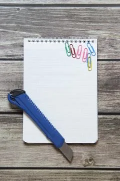 Notepad with a blank white sheet in a checker paper and with stationery knife Foto stock