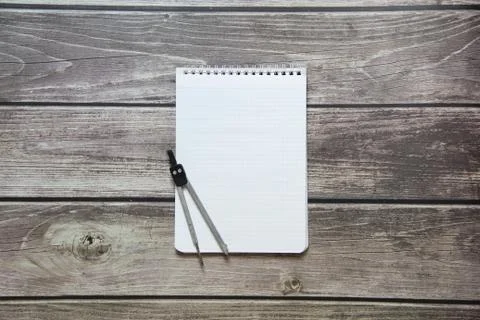 Notepad with a blank white sheet in a checker paper with compass lies on the  Stock Photos