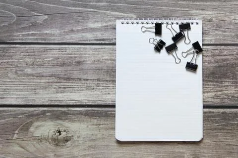 Notepad with a blank white sheet in a checker paper with a clip lies on the b Foto stock