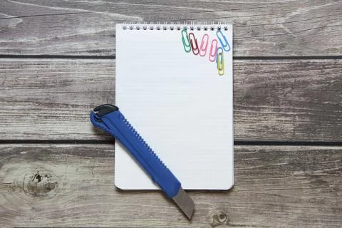 Notepad with a blank white sheet in a checker paper and with stationery knife Foto stock