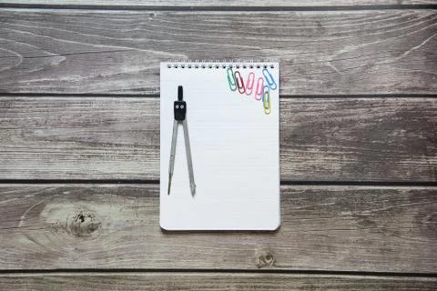 Notepad with a blank white sheet in a checker paper and with compass lies on  Foto stock