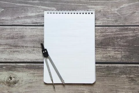 Notepad with a blank white sheet in a checker paper with compass lies on the  Foto stock