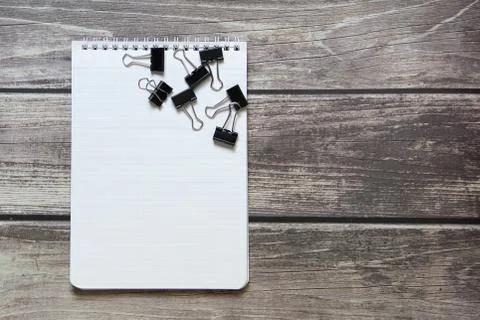 Notepad with a blank white sheet in a checker paper with a clip lies on the b Stock Photos