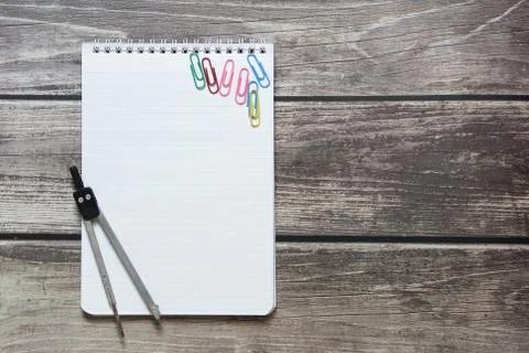 Notepad with a blank white sheet in a checker paper and with compass lies on  Foto stock