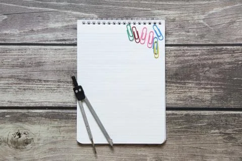 Notepad with a blank white sheet in a checker paper and with compass lies on  Stock Photos