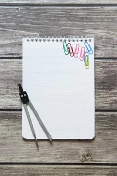 Notepad with a blank white sheet in a checker paper and with compass lies on  Stock Photos