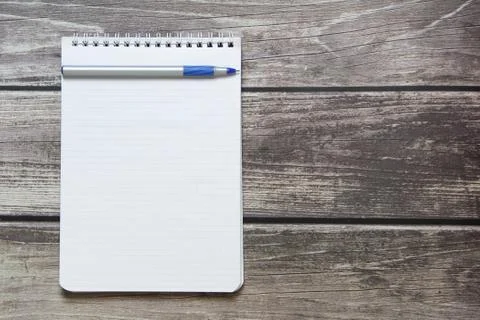 Notepad with a blank white sheet in a checker paper with ball pen lies on the Foto stock