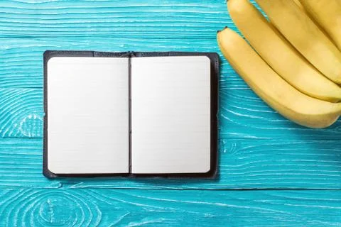 Notepad on blue wooden background surrounded by fresh fruit Stock Photos