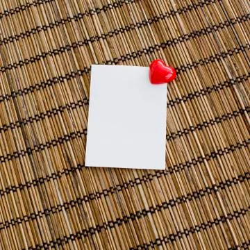 Notepad with clip of heart shape with red color on wood background Stock Photos