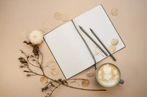 Notepad copyspace, gray pencils and cup of latte  on tan begie background Stock Photos