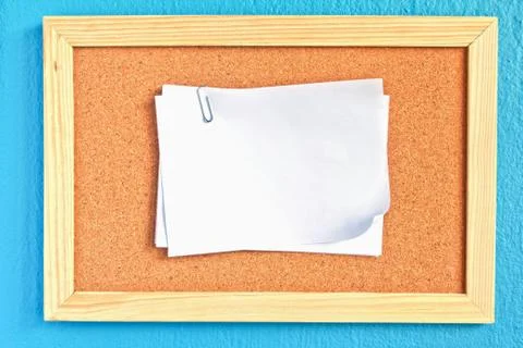 Notepad on cork board on sky-blue background Stock Photos