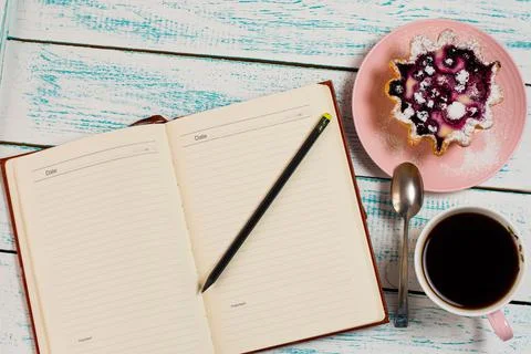 Notepad, a cup of coffee and a cake basket with berries and cottage cheese on Stock Photos