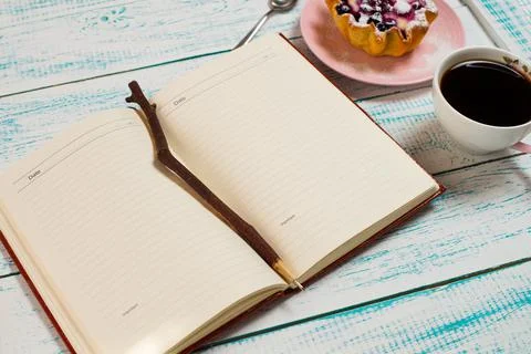 Notepad, a cup of coffee and a cake basket with berries and cottage cheese on Stock Photos
