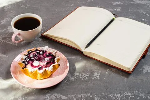Notepad, a cup of coffee and a cake basket with berries and cottage cheese on Stock Photos