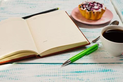 Notepad, a cup of coffee and a cake basket with berries and cottage cheese on Stock Photos