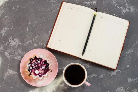 Notepad, a cup of coffee and a cake basket with berries and cottage cheese on Stock Photos