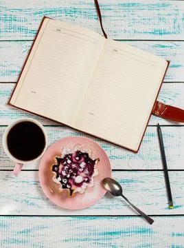 Notepad, a cup of coffee and a cake basket with berries and cottage cheese on Stock Photos