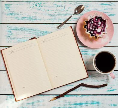 Notepad, a cup of coffee and a cake basket with berries and cottage cheese on Stock Photos