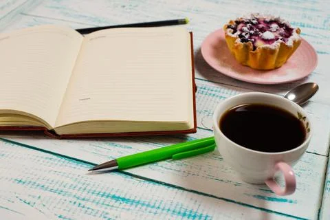 Notepad, a cup of coffee and a cake basket with berries and cottage cheese on Stock Photos