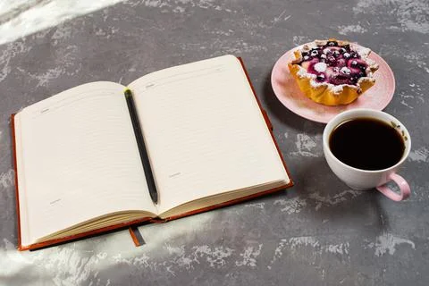 Notepad, a cup of coffee and a cake basket with berries and cottage cheese on Stock Photos