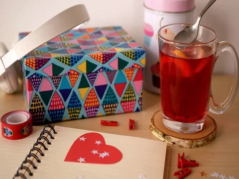 Notepad with a cup of tea and color box in the background. Stock Footage
