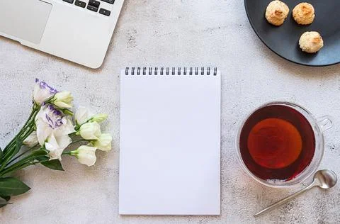 A notepad for daily planning with breakfast setting, laptop and flowers Stock Photos