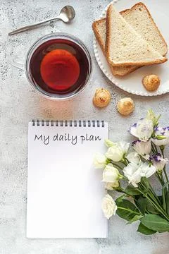 A notepad for daily planning with breakfast setting and flowers Foto stock