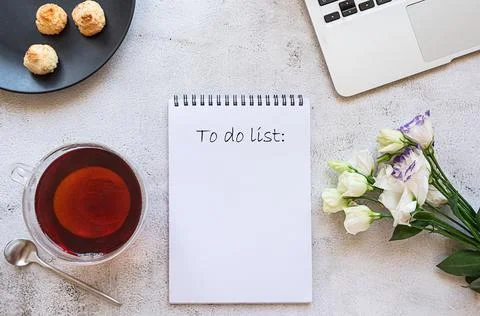 A notepad for daily planning with breakfast setting, laptop and flowers Stock Photos