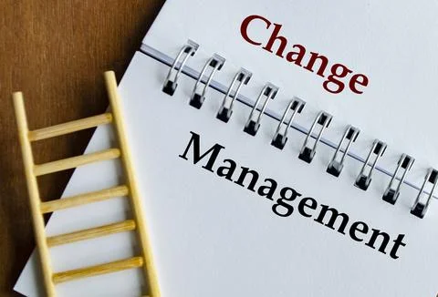 Notepad displaying Change Management in bold text with ladder on wooden sur.. Stock Photos