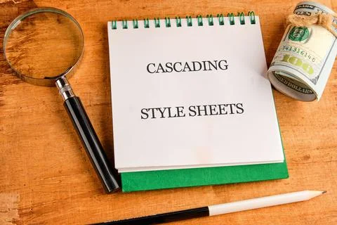 A notepad displays the phrase cascading style sheets alongside a magnifying g Stock Photos