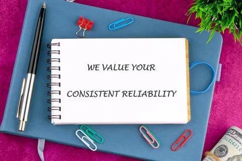 A notepad displays the text WE VALUE YOUR CONSISTENT RELIABILITY resting on a Stock Photos