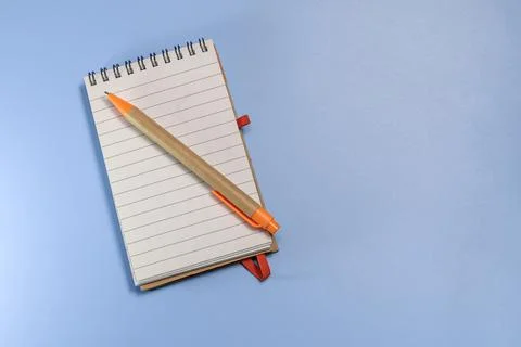 Notepad with eco pen on blue background. Sketchbook made of craft paper and a Stock Photos