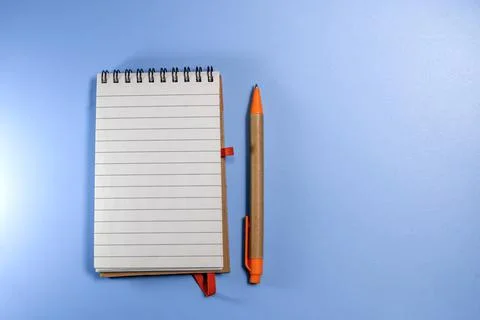 Notepad with eco pen on blue background. Sketchbook made of craft paper and a Stock Photos