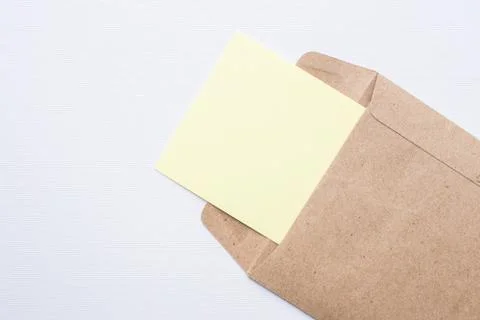 Notepad in the envelope on white canvas background Stock Photos