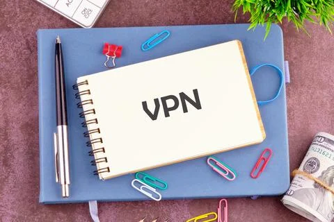 A notepad featuring the abbreviation VPN is set on a desk surrounded by color Stock Photos
