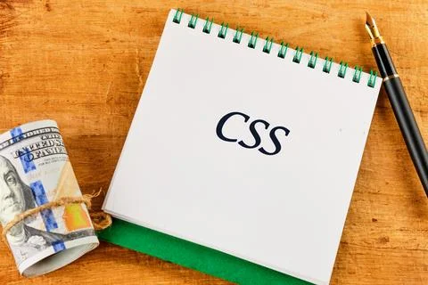 A notepad featuring the acronym CSS is placed on a wooden table, accompanie.. 스톡 사진