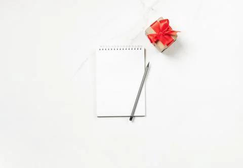 Notepad festive gift box on white background. Flat layout copy space Stock Photos