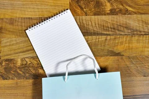 Notepad in Gift Bag on Wooden Table Surface Featuring Organized Lines Stock Photos
