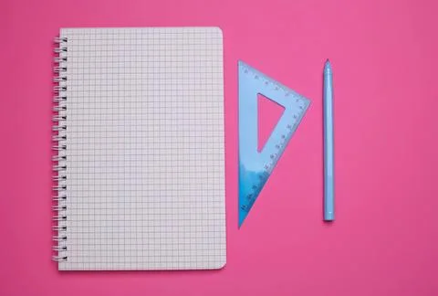 Notepad with grid paper, ruler, and pencil on pink background Stock Photos