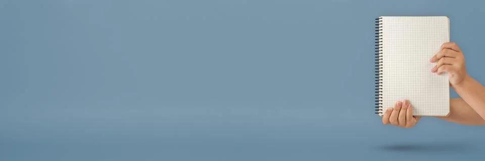 Notepad in hand. Blank notepad in the hands on a blue background. Hands hold a Foto stock