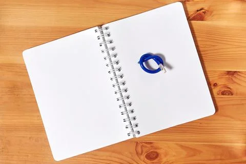 A notepad with knotted broken pencil on it Stock Photos