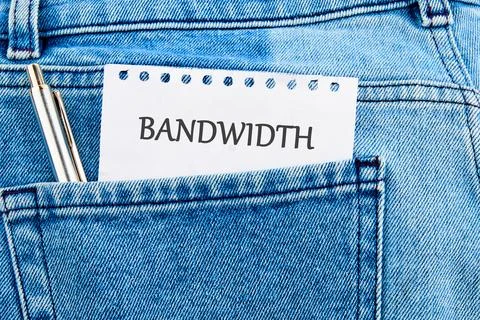 A notepad labeled bandwidth peeks from a jeans pocket, underscoring the vital Stock Photos
