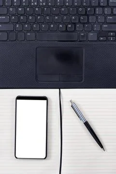 Notepad, laptop and bezel less smartphone with blank screen. Stock Photos