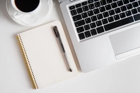 Notepad, laptop and coffee cup on wood table Stock Photos
